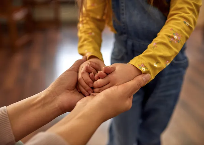 mother holding little girls hands